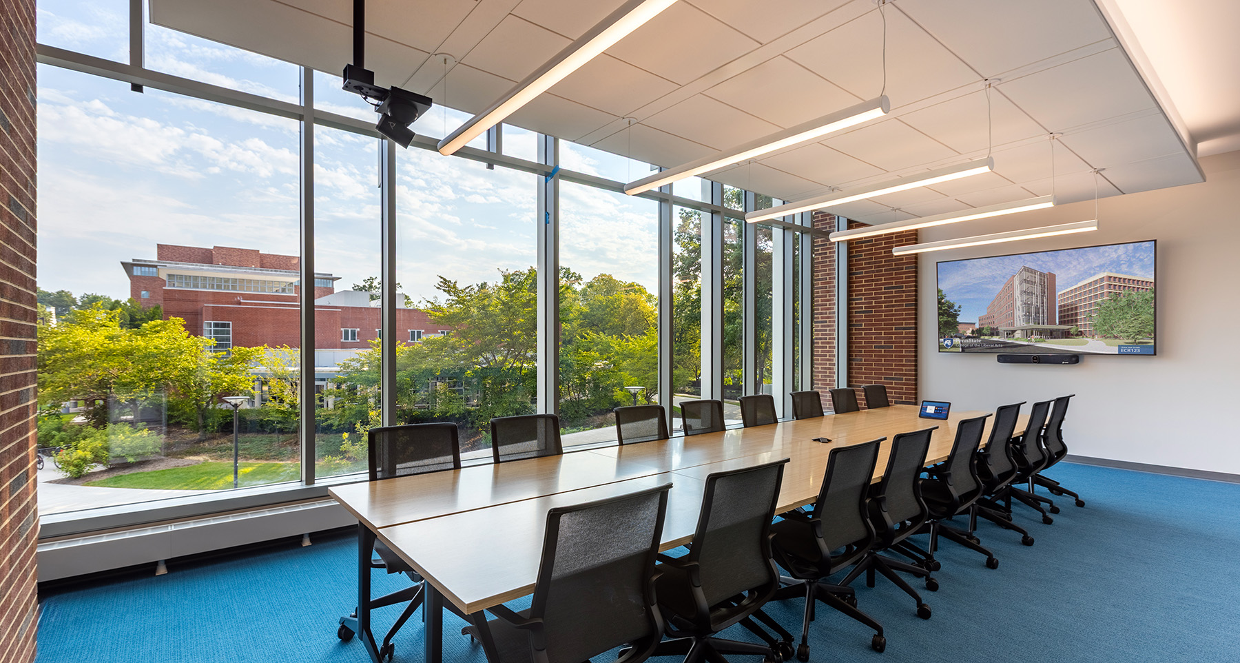 University meeting room with Crestron control panel and Zoom Rooms-enabled conferencing system