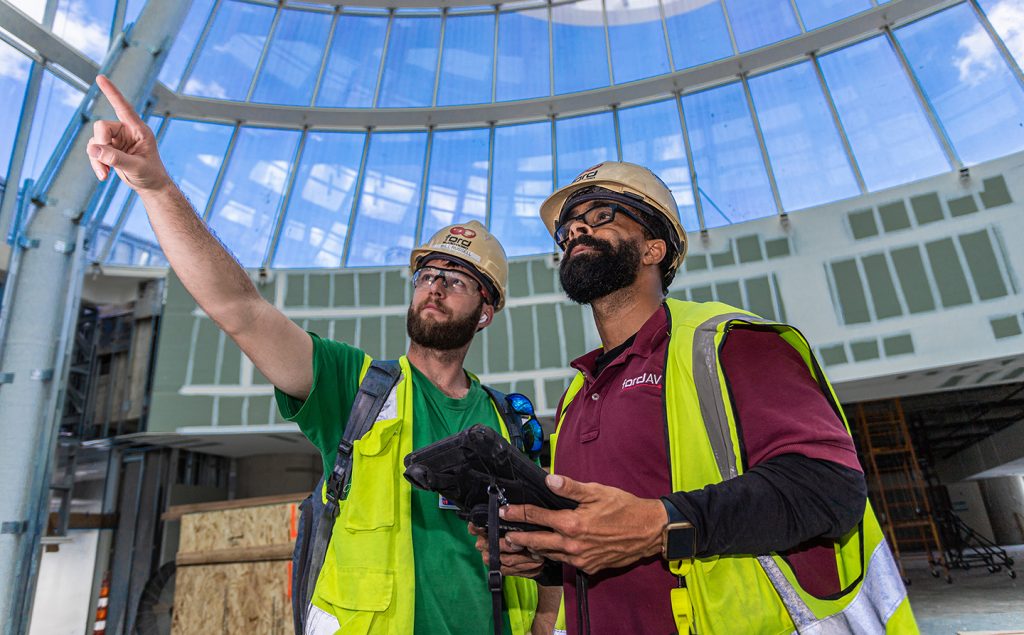 Two Ford AV San Francisco technicians installing audiovisual systems on construction site